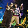 Dschungelbuch - das Musical_Pressebild 01_quer.jpg Drei Darsteller in Kostümen bewegen sich fröhlich auf einer tropischen Dschungel-Bühne.