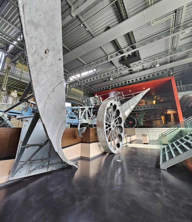 Emsland Moormuseum, Geeste – Mammut in Ausstellungshalle ©Emsland Tourismus GmbH Großes historisches Torfabbaugerät mit riesigem Metallrad in moderner Ausstellungshalle.
