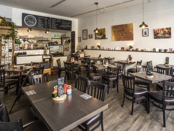 Bistro GreenBee Innenansicht Tische und Stühle sowie Tresen im Bistro GreenBee