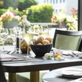 Weeken-Brunch - Im exklusiven Raum Das Bild zeigt einen stilvoll gedeckten Tisch mit einem Brotkorb und Weingläsern in einem lichtdurchfluteten Raum. Der Hintergrund ist mit Blumenarrangements geschmückt, die eine einladende und elegante Atmosphäre schaffen.The picture shows a stylishly laid table with a bread basket and wine glasses in a light-flooded room. The background is decorated with floral arrangements that create an inviting and elegant atmosphere.
