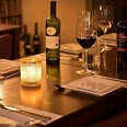 Dinner - Im Restaurant Gemütliches Restaurantambiente mit Kerzenlicht, gedeckte Tische, Weinflaschen und gefüllte Gläser.Cozy restaurant ambience with candlelight, laid tables, bottles of wine and filled glasses.