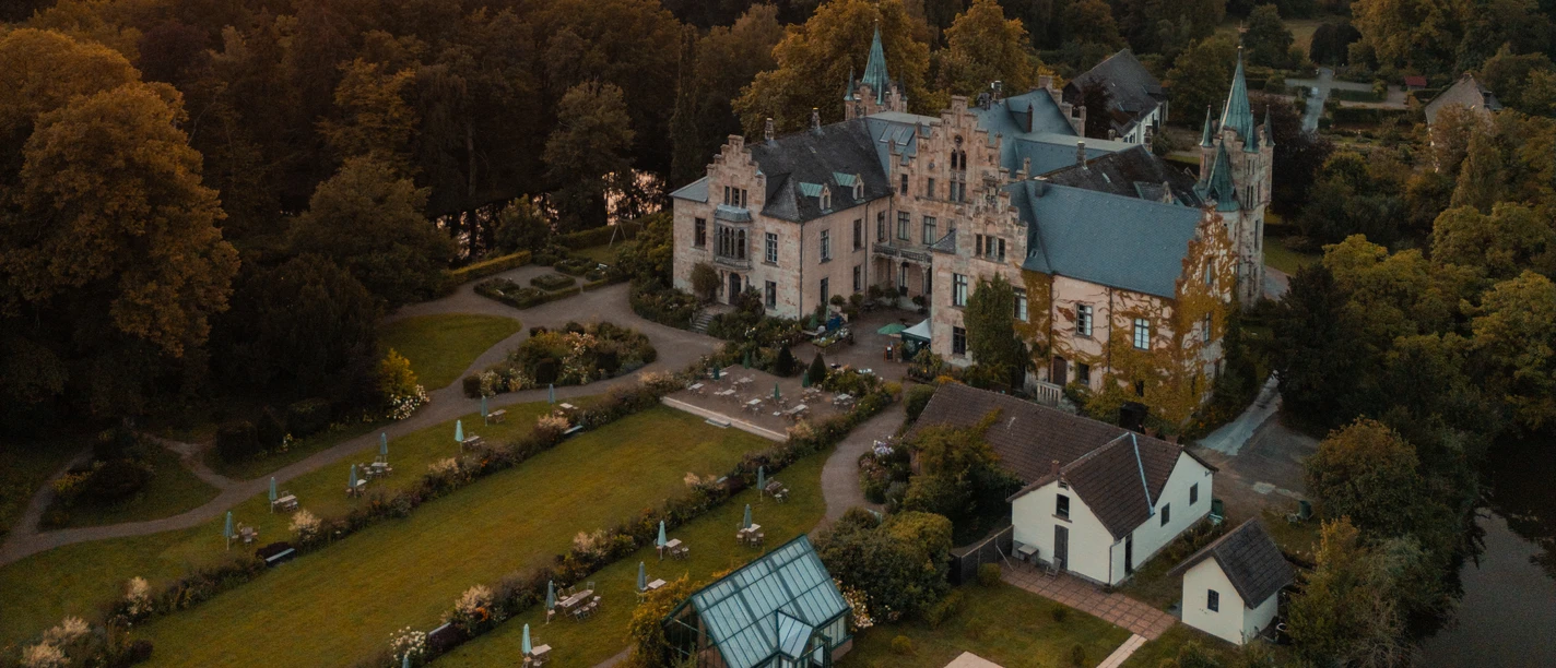 bad-essen-ippenburg-CC0-copyright-TOL-foto-erik-schroeter (1).jpg Schloss und Gartenlandschaft bei Sonnenuntergang im pastellfarbenen Abendhimmel.