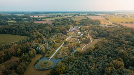 Kasteel Ippenburg van bovenaf Luchtfoto van kasteel Ippenburg omringd door uitgestrekte tuinen en een bosrijk landschap.