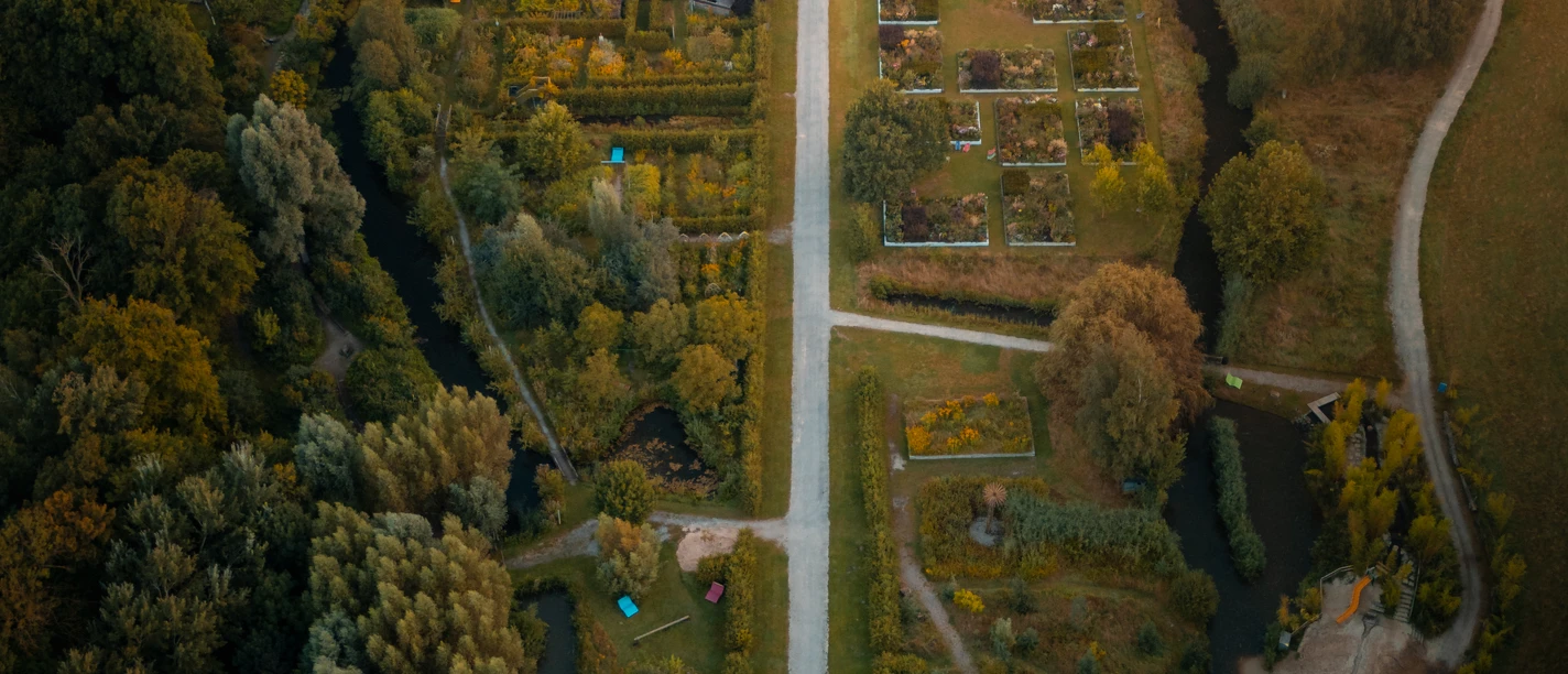 bad-essen-ippenburg-CC0-copyright-TOL-foto-erik-schroeter (2).jpg Luftaufnahme eines Parks mit symmetrischen Gärten und einem Herrenhaus im Hintergrund.