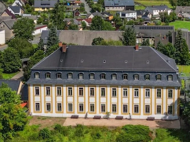 Schloss Leubnitz Historisches Schloss mit gelber Fassade und Ziegeldach in ländlicher Umgebung.