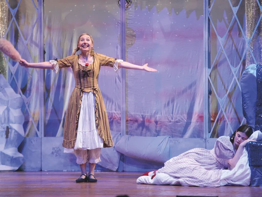 Frau Holle, Kindertheater in Espelkamp Zwei Darstellerinnen auf der Bühne: Links eine Frau im gelben Kleid, rechts ein Kind schlafend.