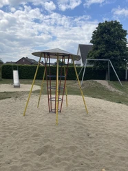 Metall-Klettergerüst mit Rutsche und Schaukel in einem Sandkasten auf einem Spielplatz.
