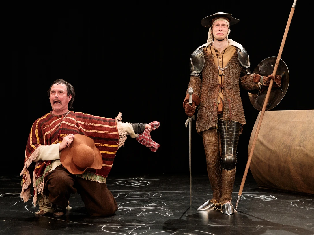 Don Quijote Zwei Schauspieler in Kostümen von Don Quijote und Sancho Panza auf einer Theaterbühne.