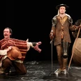 Don Quijote Zwei Schauspieler in Kostümen von Don Quijote und Sancho Panza auf einer Theaterbühne.