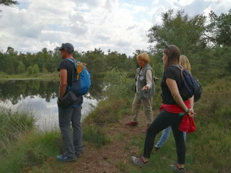 A group stands in the moor with a tour guide.