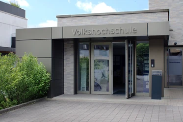 Eingang Moderner Eingang einer Volkshochschule mit barrierefreien Zugangsrampen und automatischen Türen.