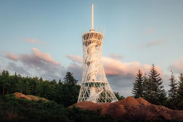 HEX Erlebniswelt Turm im Frühling Der HEX-Aussichtsturm mit spiralförmiger Struktur steht in Ellrich vor kontrastreichem Himmel im Südharz.