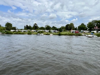 Weser-Camping Bollen direkt am Ufer mit Wohnwagen, Bäumen und bewölktem Himmel im Hintergrund.Weser-Camping Bollen directly on the riverbank with caravans, trees and a cloudy sky in the background.Weser-Camping Bollen direkte på flodbredden med campingvogne, træer og en overskyet himmel i baggrunden.Weser-Camping Bollen direct aan de rivieroever met caravans, bomen en een bewolkte lucht op de achtergrond.