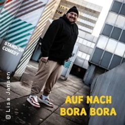 Ein humorvoller Entertainer steht lächelnd auf einer urbanen Dachterrasse.