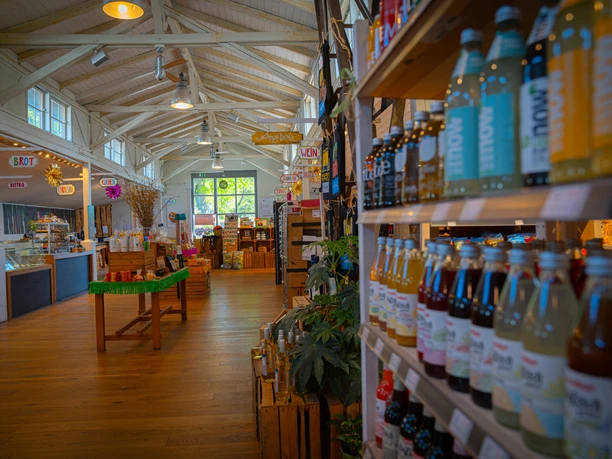 Große Auswahl an Produkten in der Moorrübe Ein Bild zeigt das Interieur eines Bioladens mit Holzdekor, vollen Regalen und einem hellen, einladenden Ambiente.