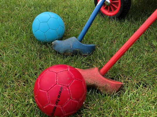 Hof Claus Bunte Spielbälle und Krokett-Schläger liegen auf grünem Gras, bereit für den nächsten Spielspaß.Colorful balls and croquet mallets lie on the green grass, ready for the next game.Farverige kugler og kroketkøller ligger på det grønne græs, klar til næste omgang sjov.Kleurrijke speelballen en croquetmallets liggen op het groene gras, klaar voor de volgende ronde plezier.