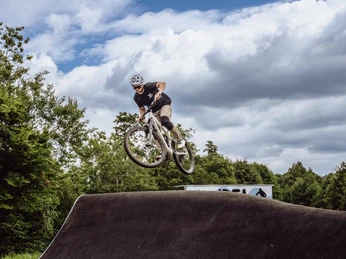 Ein Fahrradfahrer springt mit dem Fahrrad auf dem Pumptrack in Baiersbronn.