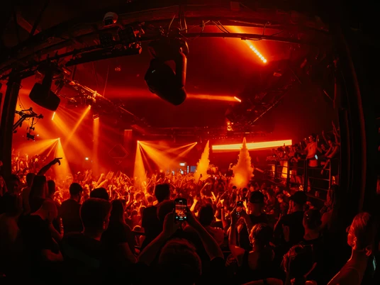 Bootshaus Mainfloor Das Bild zeigt eine lebhafte, volle Tanzfläche in einem Club, durchdrungen von roten Lichtern.The picture shows a lively, full dance floor in a club, suffused with red lights.