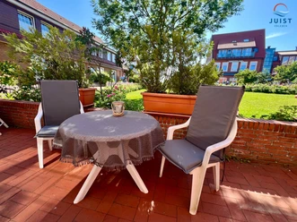 Rosengang Appartements 316 - Wohnung Dünenrose_Terrasse mit Sitzgelegenheit und Blick ins Grüne.jpg
