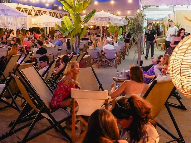 Gaia - Roof terrace Rooftop lounge at night with guests and relaxed atmosphere