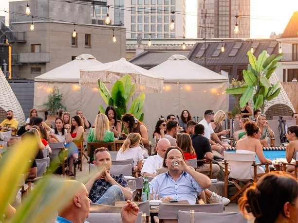 Gaia Rooftop Rooftop-Atmosphäre mit Gästen und Lichterketten im Abendlicht