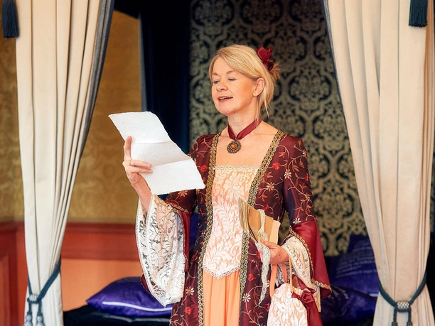 Kammerfrau Juliette liest historische Briefe im Celler Schloss Gästeführerin als Kammerfrau Juliette in historischem Kostüm liest einen Brief in einem prunkvollen Raum des Celler Schlosses