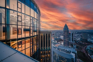 TOWER185/FIFTY HEIGHTS - Aussicht Glasfassade eines Hochhauses mit Blick auf Frankfurts Skyline bei Sonnenuntergang.