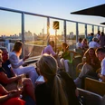 Sunset at Upper East Side Guests enjoying evening on rooftop terrace at sunset.