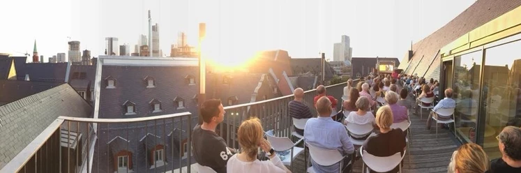 Haus am Dom - Dachterrasse Publikum bei Open-Air-Event auf der Dachterrasse im Sonnenuntergang