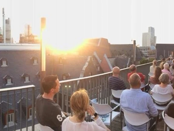 Haus am Dom - Dachterrasse Publikum bei Open-Air-Event auf der Dachterrasse im Sonnenuntergang