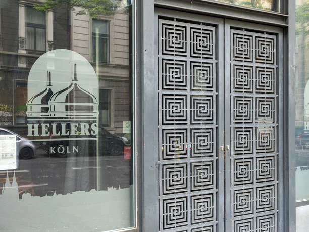 HELLERS Brewery The front of a building with large glass doors and windows, decorated with graphic patterns and lettering.