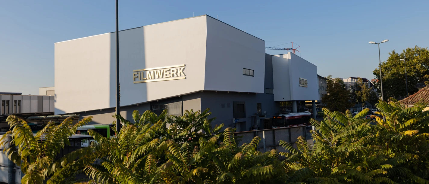 Außenaufnahme vom Filmwerk mit Bäumen im Vordergrund