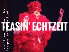 Eine auffällige Person in glamourösem, rotem Kostüm bei einer Burlesque-Vorstellung auf der Bühne.