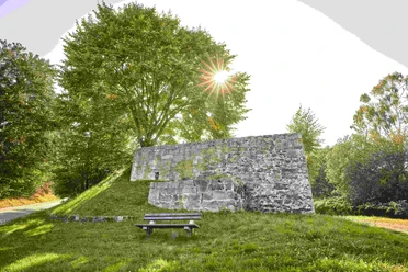 Kalkofen Giesenstein Kalkofen Giesenstein an einem sonnigen Tag, umgeben von grünen Bäumen und einer grasbewachsenen Bank.