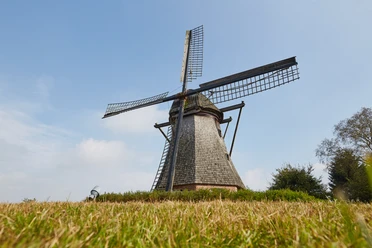 Hilter Mühle bei Lathen – Radfahrer auf dem Hilter Berg ©Naturpark Hümmling (53).jpg Historische Windmühle auf dem Hilter Berg bei Lathen vor blauem Himmel und grüner Wiese