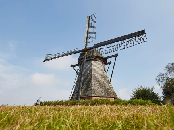 Hilter Mühle bei Lathen – Radfahrer auf dem Hilter Berg ©Naturpark Hümmling (53).jpg Historische Windmühle auf dem Hilter Berg bei Lathen vor blauem Himmel und grüner Wiese