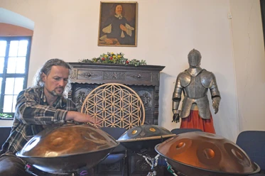Campana Festival Schloss Rochsburg De foto toont een muzikant die op zijn klankschalen speelt.