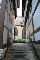 Fachwerkpatt Schmaler Durchgang zwischen Fachwerkhäusern mit Stufen, Laterne und Blick auf Steingebäude.