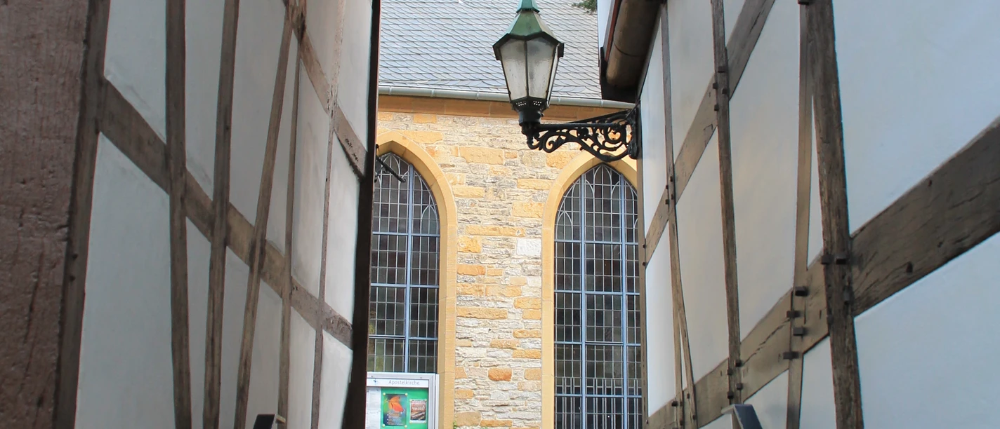 Fachwerkpatt Schmaler Durchgang zwischen Fachwerkhäusern mit Stufen, Laterne und Blick auf Steingebäude.
