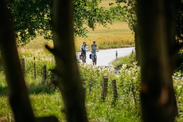 Radfahrende unterwegs auf der Düte-Tour Radfahrende unterwegs auf der Düte-Tour, entlang naturnaher Wege durch Felder und Grünflächen.