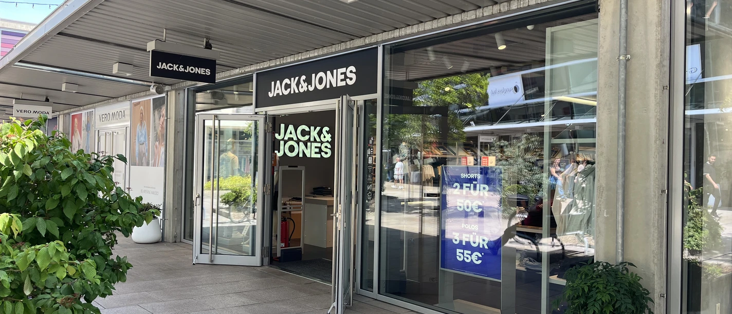 Jack&Jones Outlet Shop Eingangsbereich des Jack & Jones Geschäfts mit offenen Glastüren und Schaufenstern.
