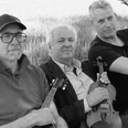 CELTIC MOODS Drei Musiker mit Instrumenten im Freien. Alle drei Männer blicken ernst in die Kamera.