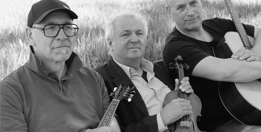 CELTIC MOODS Drei Musiker mit Instrumenten im Freien. Alle drei Männer blicken ernst in die Kamera.