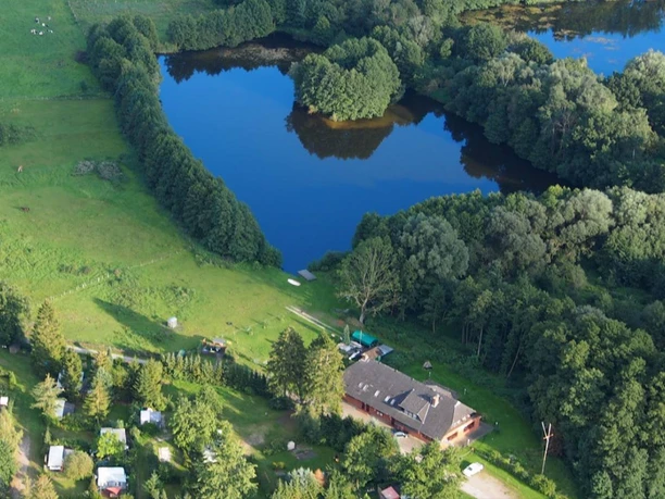 Campingplatz Zur Fähre Der Campingplatz Zur Fähre liegt an einem ruhigen See, umgeben von grünen Wiesen und Wald.
