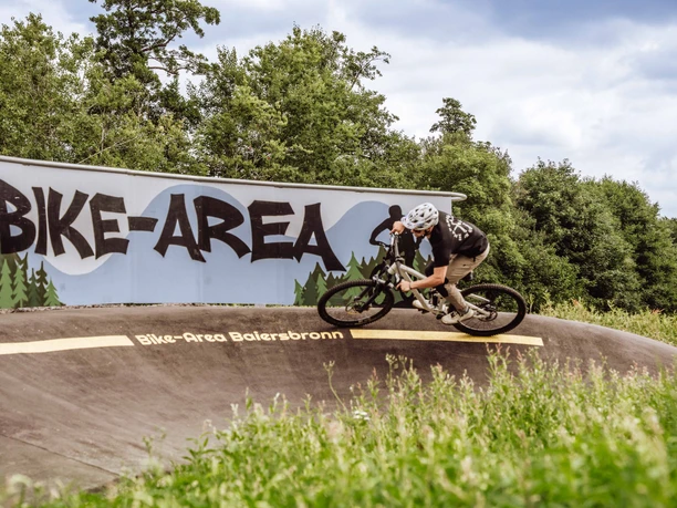 Ein Fahrradfahrer fährt über den Pumptrack in Baiersbronn