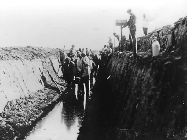 Das Moor musste zunächst trockengelegt werden, um es kultivieren zu können. Gräben mit fast senkrechten Böschungen entstanden Arbeiter graben tiefe Entwässerungsgräben im Moor, um das Land für Ackerbau nutzbar zu machen.