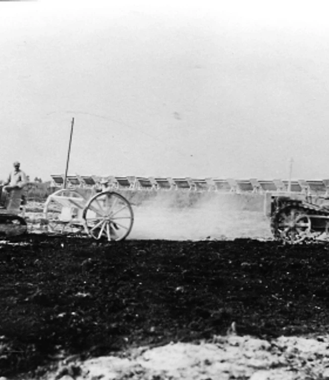 Feldbahnen schafften Kalk heran, der ausgestreut wurde. Nachdem der tiefgepflügte Boden soweit hergerichtet war, war die Moorverwaltung für die weitere Bearbeitung zuständig. Arbeiter mit Feldbahn und Traktoren verteilen Kalk auf gepflügtem Moorboden zur Bodenverbesserung.