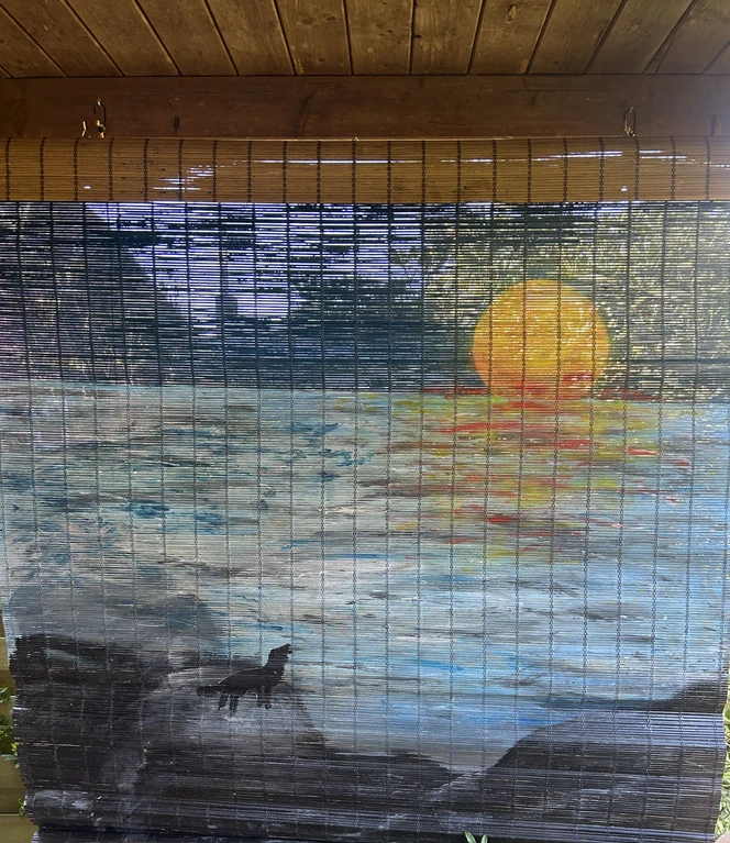 Ein einsamer Wolf, der den Mond anheult, ziert das Bambusrolle, welches als Sonnenschutz dient..