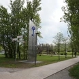 Freizeitpark Nordstadt an der Höferstraße in Velbert-Mitte Großer Freizeitpark mit Holzspielplatz, gepflasterten Wegen vor üppigen Bäumen und moderner Skulptur.