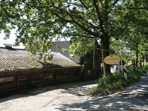 Örkhof mit Hofladen Velbert Eingang zum Örkhof mit Hofladen in Velbert, umgeben von grünen Bäumen und ländlichen Gebäuden.